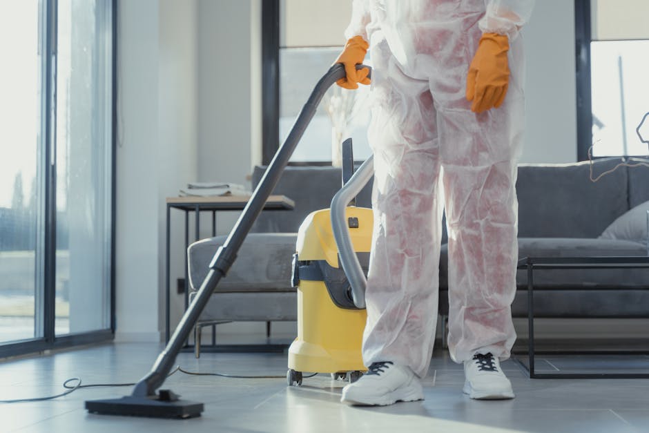 A dustpan and brush set hanging on a white wall, with the dustpan made of light blue plastic and the brush featuring a wooden handle and natural bristles. The cleaning tools are positioned together, w